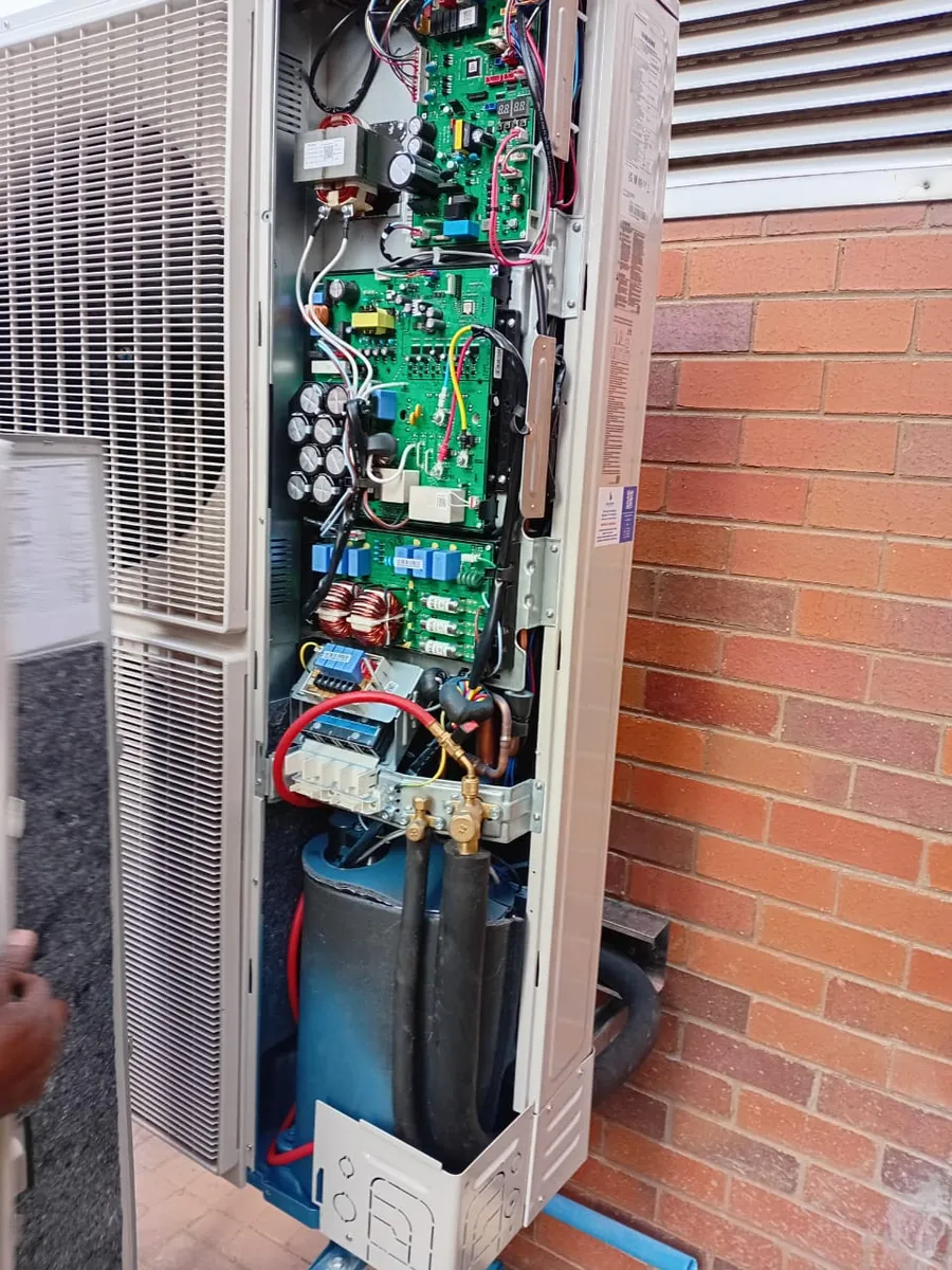 Outdoor unit opened up with its control board exposed during a repair